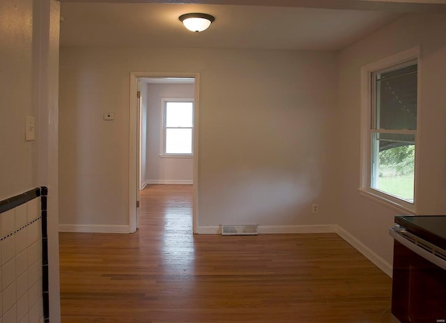 unfurnished room with visible vents, baseboards, and wood finished floors