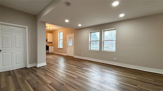 unfurnished living room featuring dark wood finished floors, recessed lighting, and baseboards