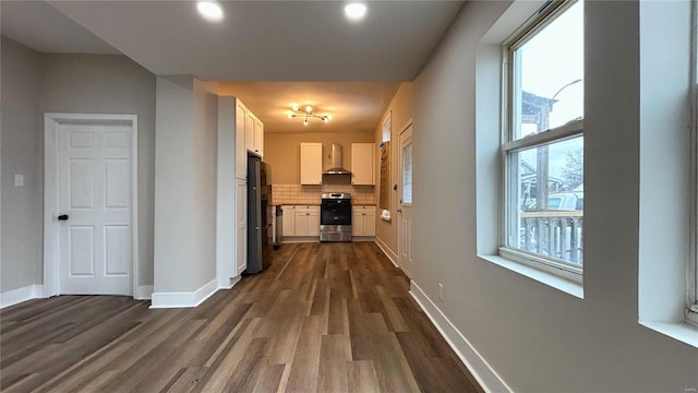 hall featuring baseboards and dark wood-style flooring