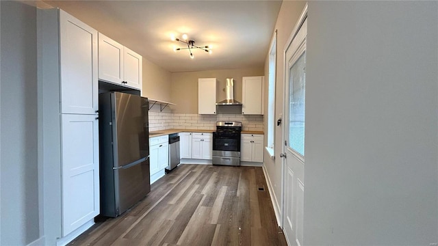 kitchen featuring stainless steel appliances, dark wood-type flooring, white cabinetry, wall chimney exhaust hood, and backsplash