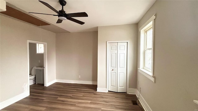 unfurnished bedroom featuring baseboards, a ceiling fan, wood finished floors, and ensuite bathroom