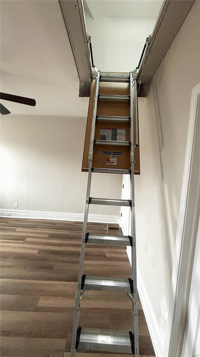 stairs with a ceiling fan, baseboards, and wood finished floors