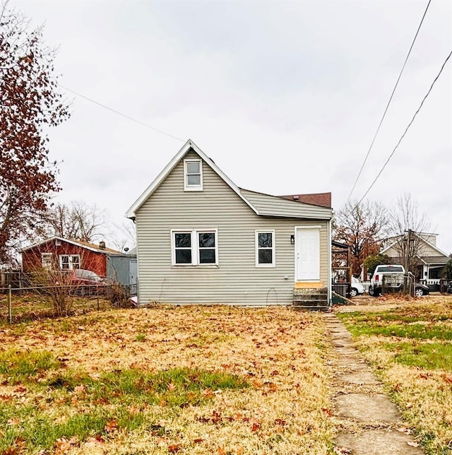 back of property featuring entry steps and fence