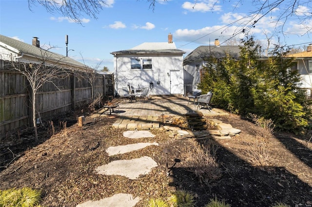 back of house with an outdoor fire pit, fence, a chimney, and a patio