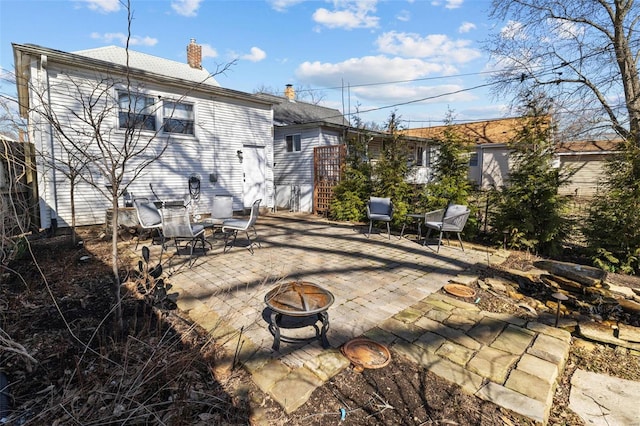 back of property with a fire pit and a patio area