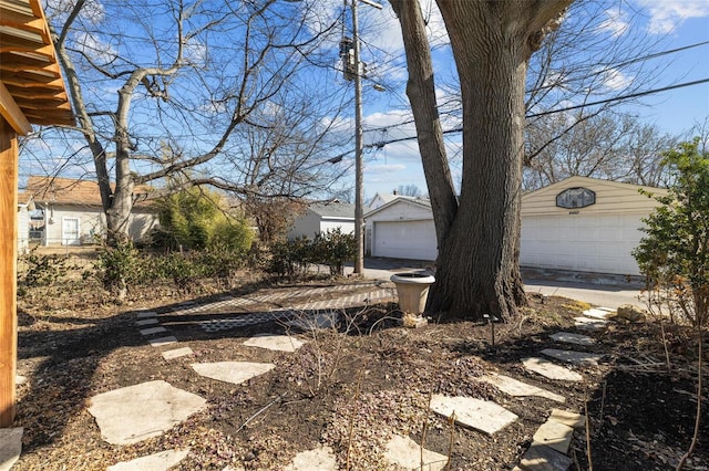 view of yard with a garage and an outbuilding