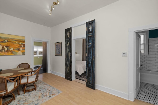 dining area featuring light wood-type flooring and baseboards