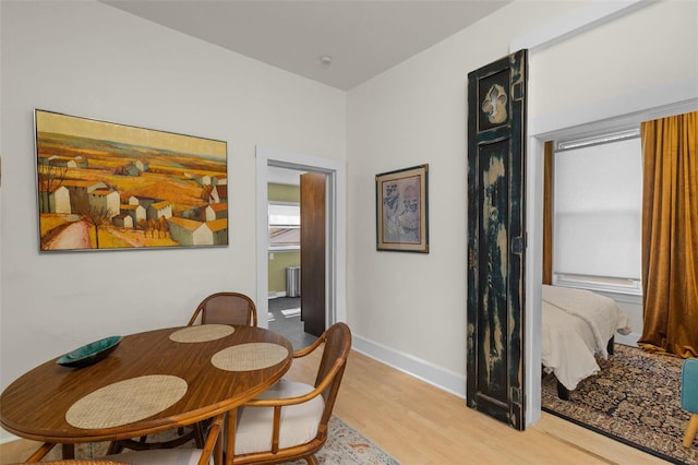 dining area featuring light wood-type flooring and baseboards