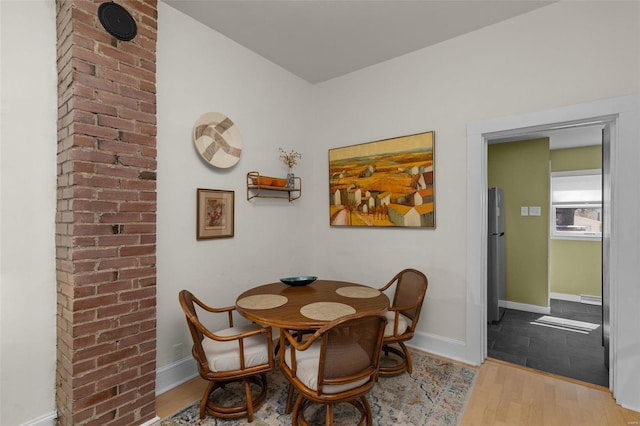 dining space featuring baseboards and wood finished floors