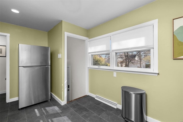 kitchen with freestanding refrigerator, visible vents, dark tile patterned floors, and baseboards