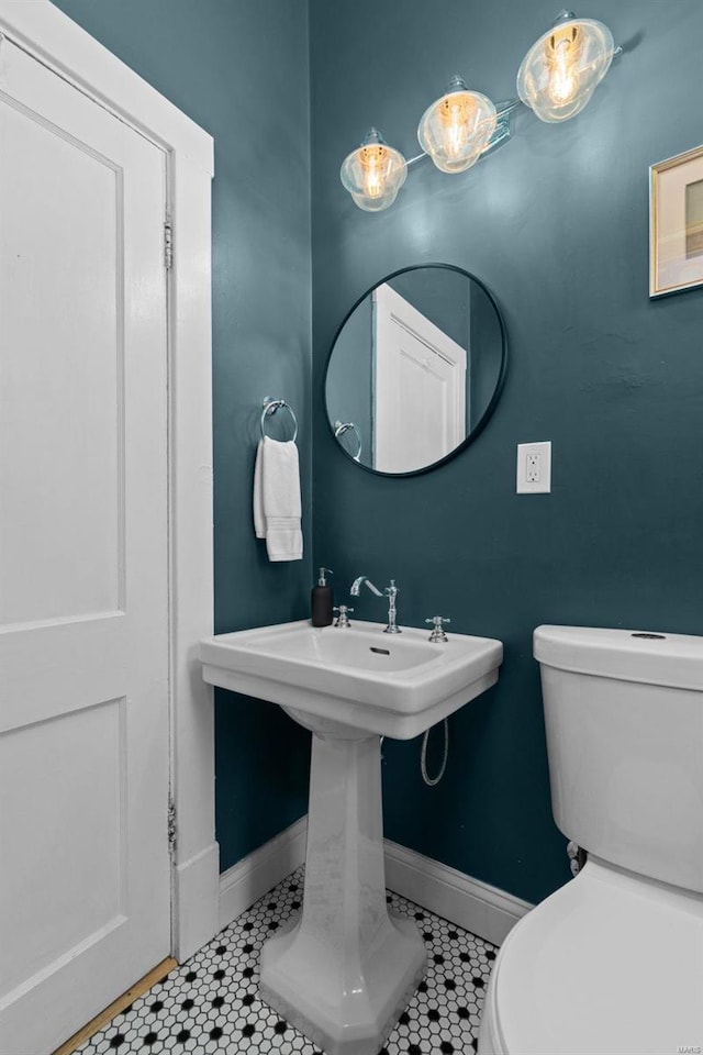 bathroom with toilet, tile patterned flooring, and baseboards