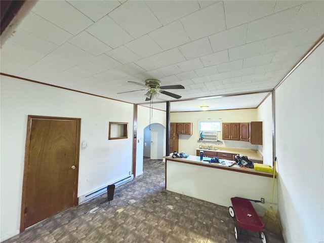 kitchen with ceiling fan, arched walkways, baseboard heating, and crown molding