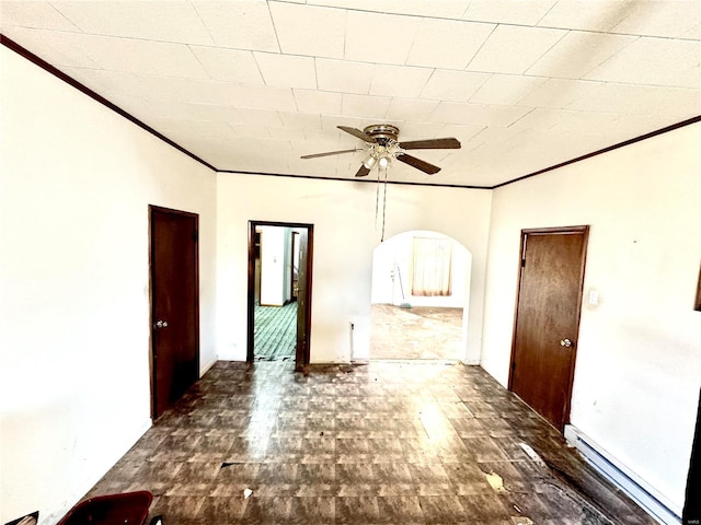 empty room featuring ornamental molding, a baseboard radiator, arched walkways, and a ceiling fan