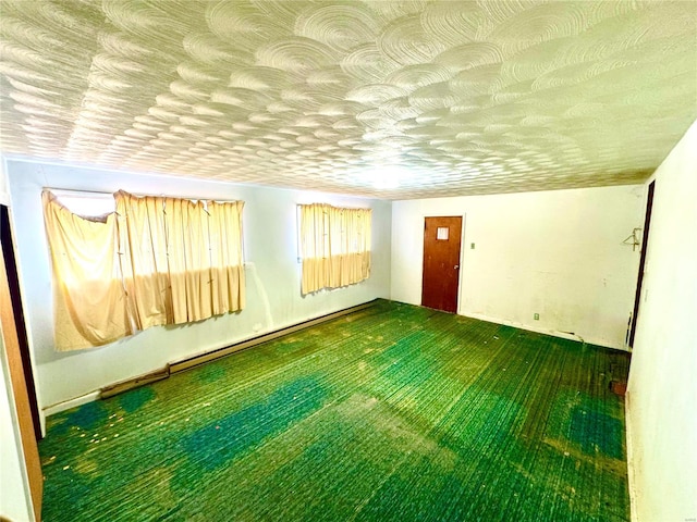 empty room featuring carpet floors, baseboard heating, and a textured ceiling