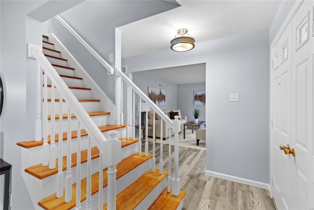 stairs with wood finished floors and baseboards