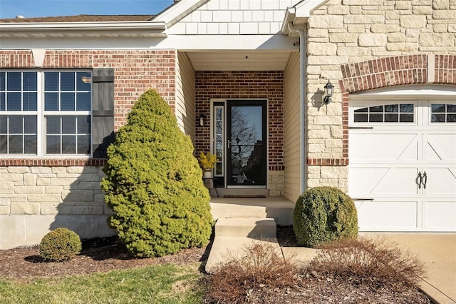 doorway to property featuring a garage and brick siding