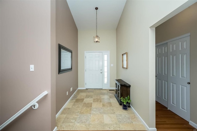 foyer with baseboards and stone finish floor