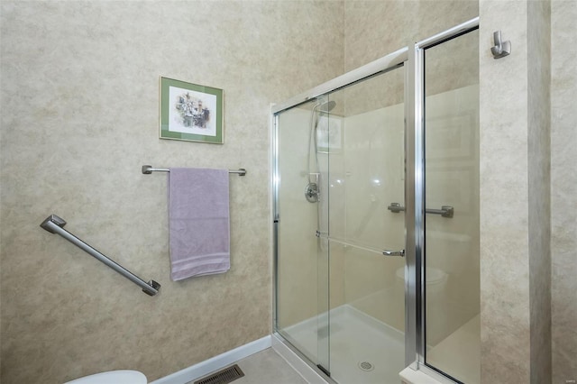 bathroom featuring visible vents, toilet, and a shower stall