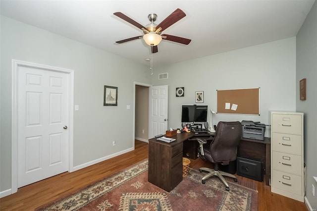 home office featuring visible vents, baseboards, ceiling fan, and wood finished floors