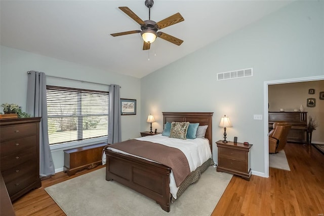 bedroom featuring vaulted ceiling, light wood-style flooring, baseboards, and visible vents