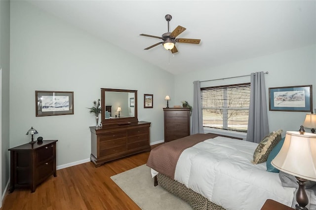 bedroom with ceiling fan, baseboards, lofted ceiling, and wood finished floors