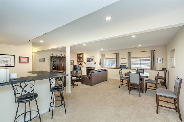 dining area with recessed lighting, a fireplace, baseboards, light colored carpet, and a dry bar