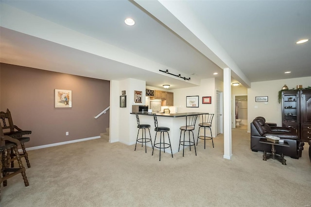 kitchen with a breakfast bar, recessed lighting, open floor plan, and light carpet