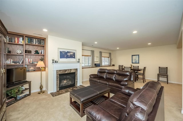 carpeted living room with recessed lighting, baseboards, and a high end fireplace