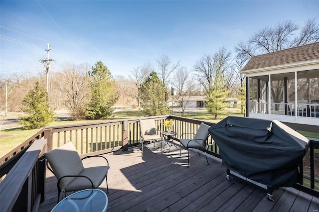 deck featuring a sunroom and a grill