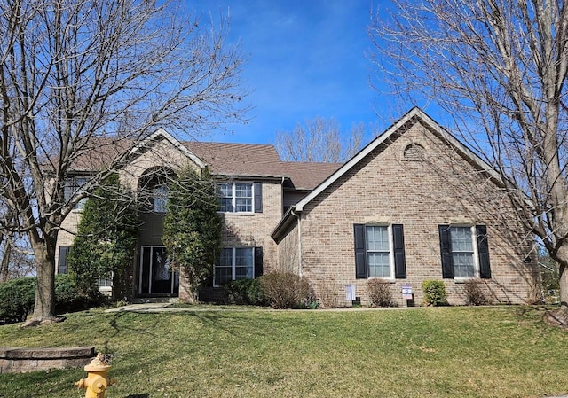 traditional-style house with brick siding and a front lawn