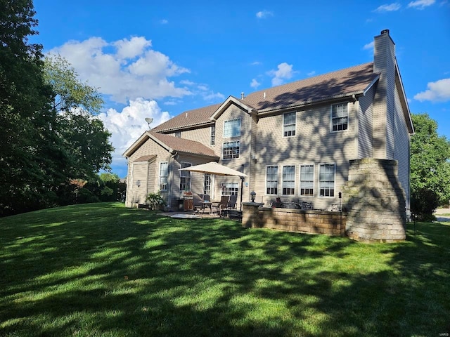 back of property with a patio area, a chimney, and a yard