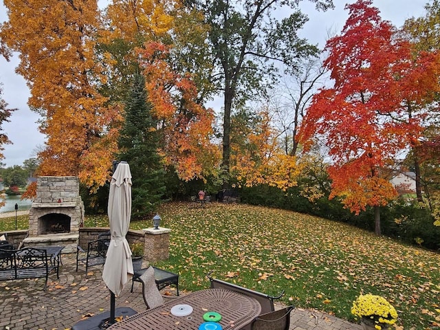 view of yard featuring a patio area and an outdoor stone fireplace