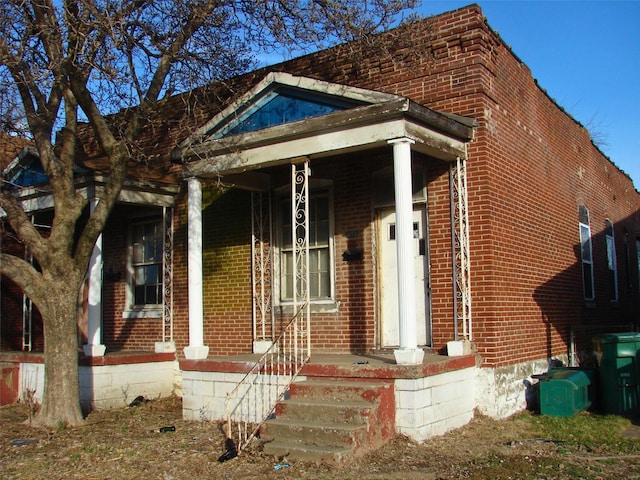 view of front of home with covered porch and brick siding