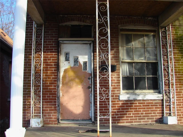 view of exterior entry featuring brick siding