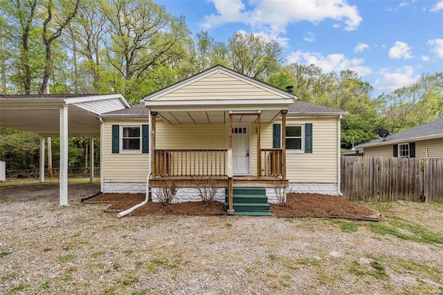 bungalow-style home featuring fence, a porch, and roof with shingles