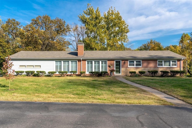 single story home with brick siding, a chimney, and a front lawn