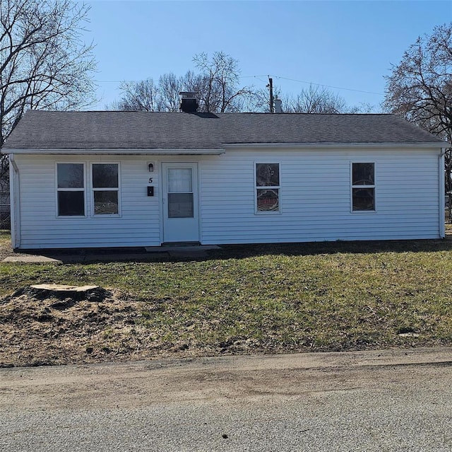 view of front of house featuring a front lawn and roof with shingles