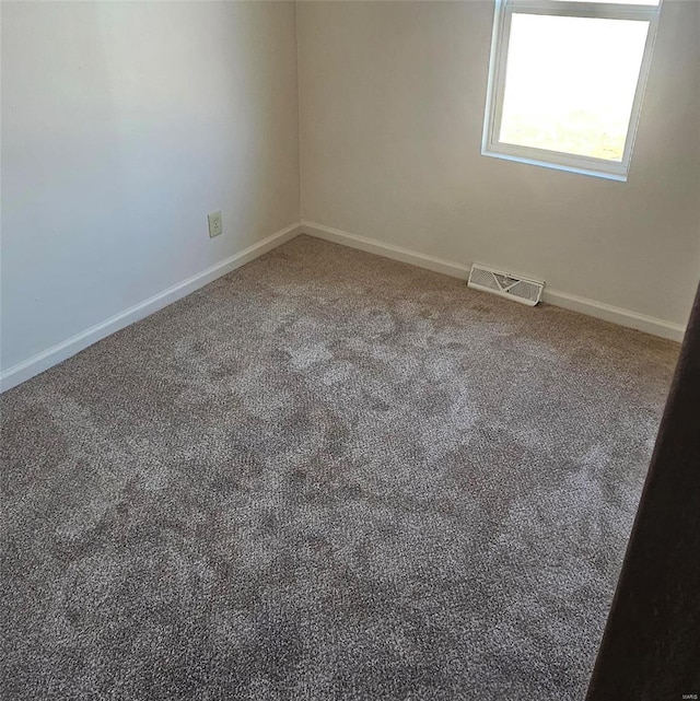 carpeted empty room with visible vents and baseboards