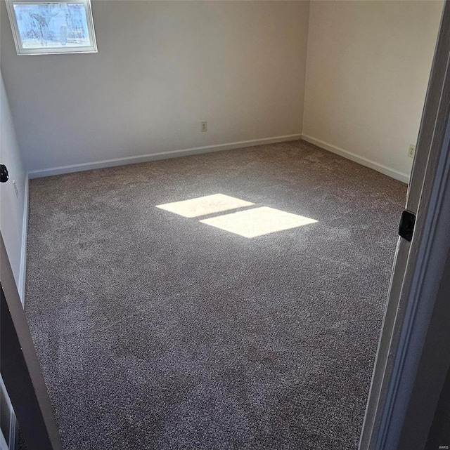 spare room with carpet and baseboards