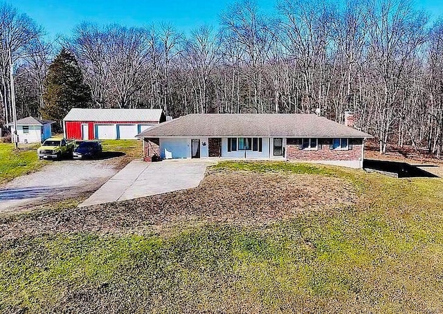 ranch-style home featuring driveway and a front lawn