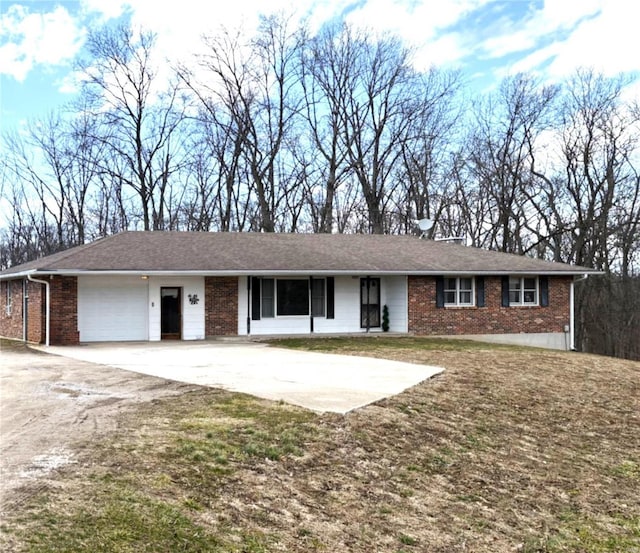 ranch-style home featuring a garage, driveway, and brick siding