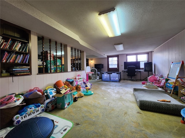 game room with concrete floors and a textured ceiling