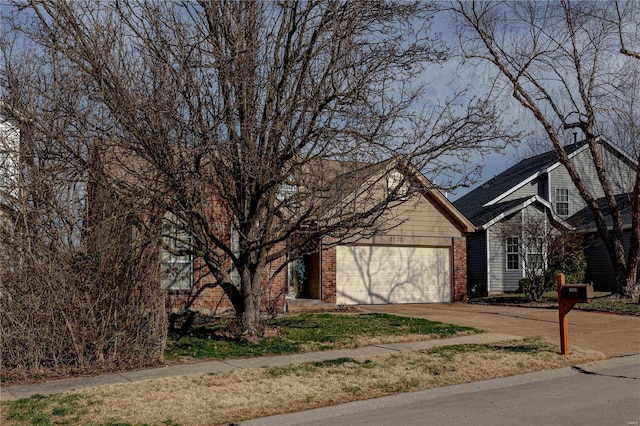 obstructed view of property featuring brick siding, driveway, and a garage