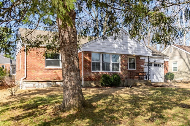 view of front of house with a garage, brick siding, and a front lawn