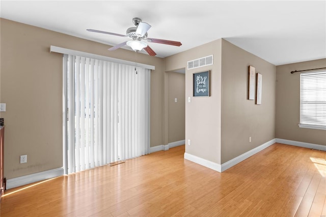 unfurnished room with visible vents, baseboards, light wood-style floors, and a ceiling fan