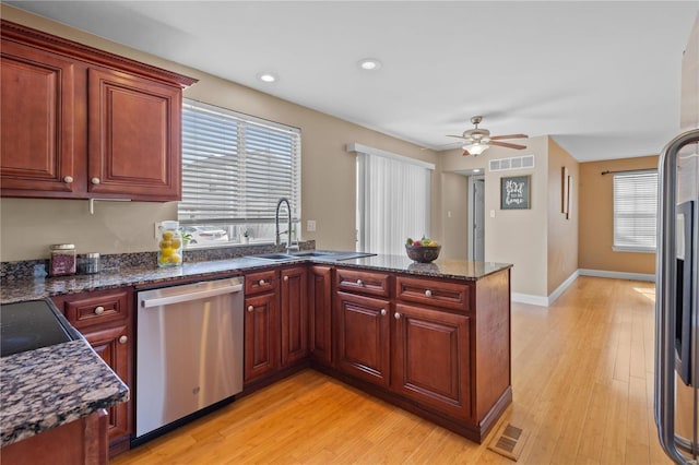 kitchen with visible vents, appliances with stainless steel finishes, a peninsula, and a sink