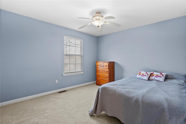 carpeted bedroom with visible vents, baseboards, and ceiling fan