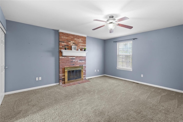 unfurnished living room featuring ceiling fan, a brick fireplace, baseboards, and carpet