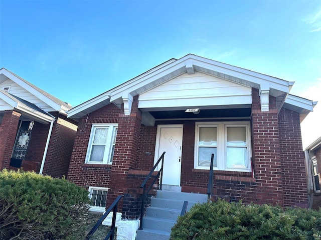 view of front of home with entry steps and brick siding