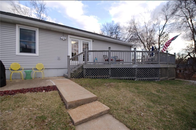 back of house with a deck and a lawn